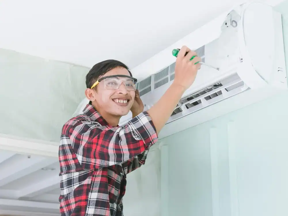 Technician servicing a wall-mounted home air conditioner